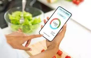 Tracking daily calories with mobile app in kitchen.