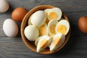 Hard boiled eggs with some sliced in a bowl