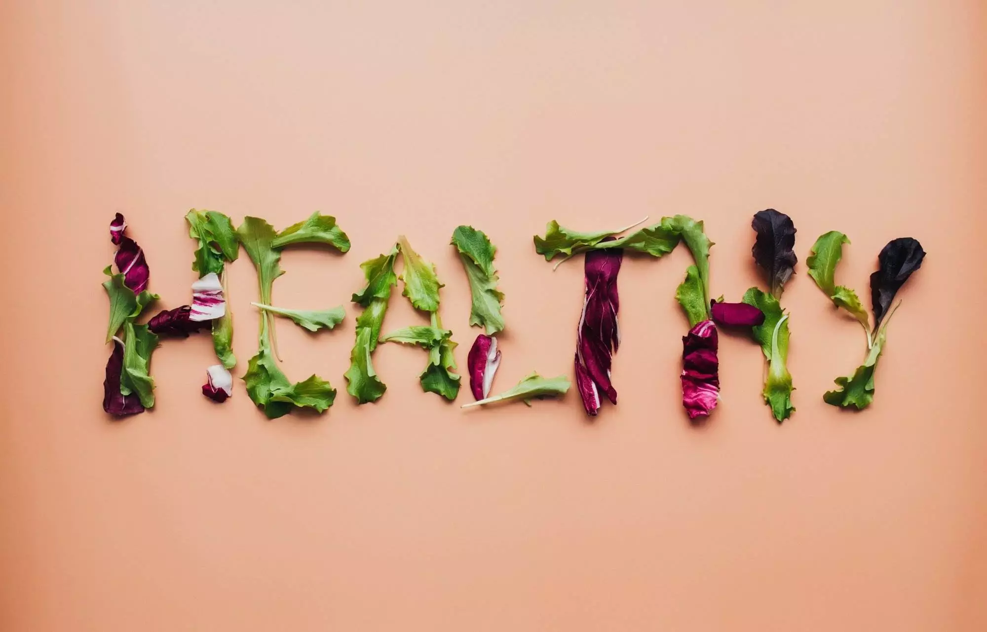 Healthy word spelled with fresh green salad leaves.