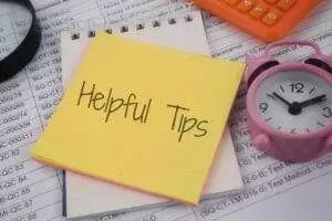 Helpful tips on yellow sticky note with clock and calculator