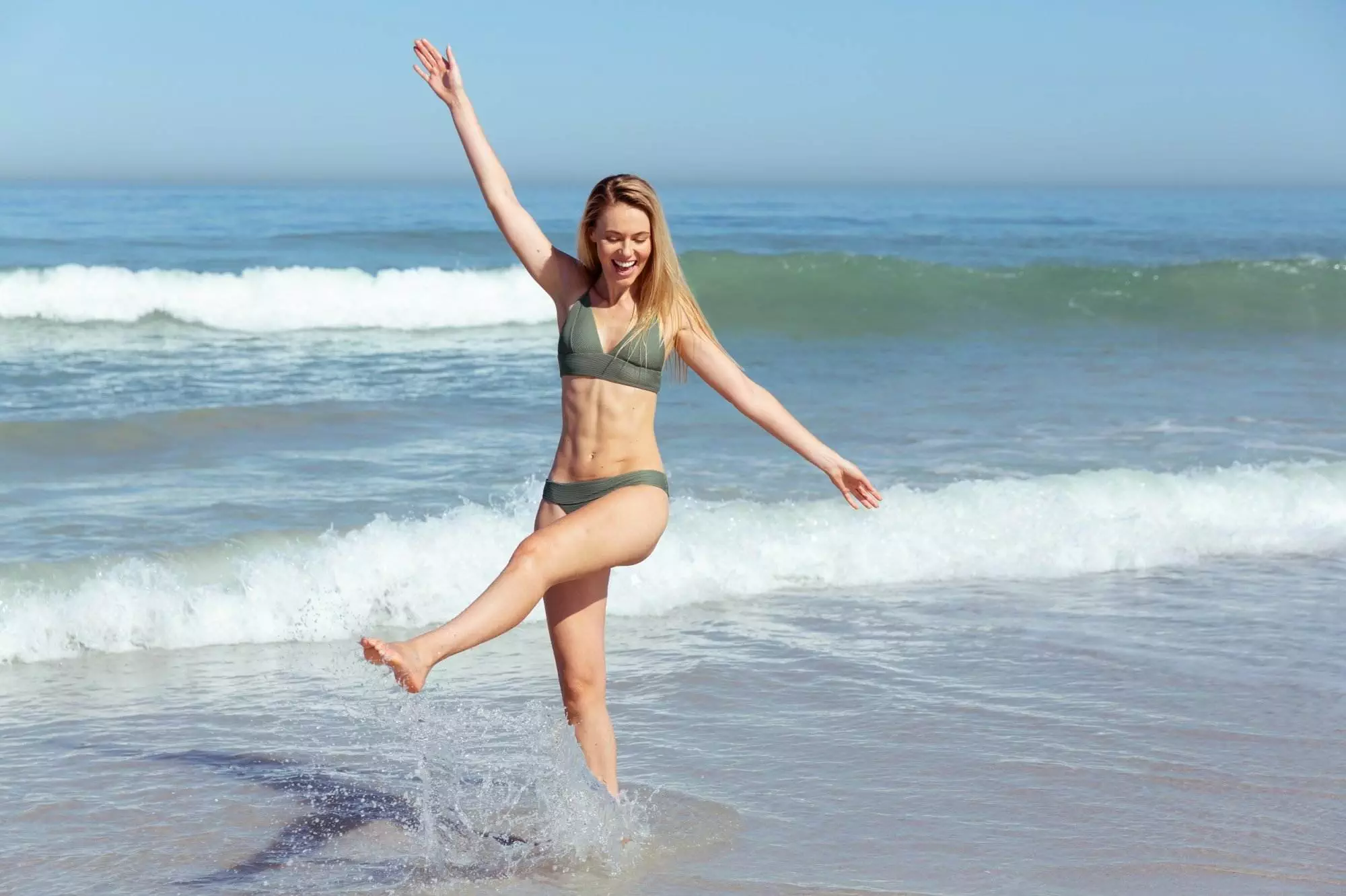 Woman playing in the ocean waves. Keto weight loss.