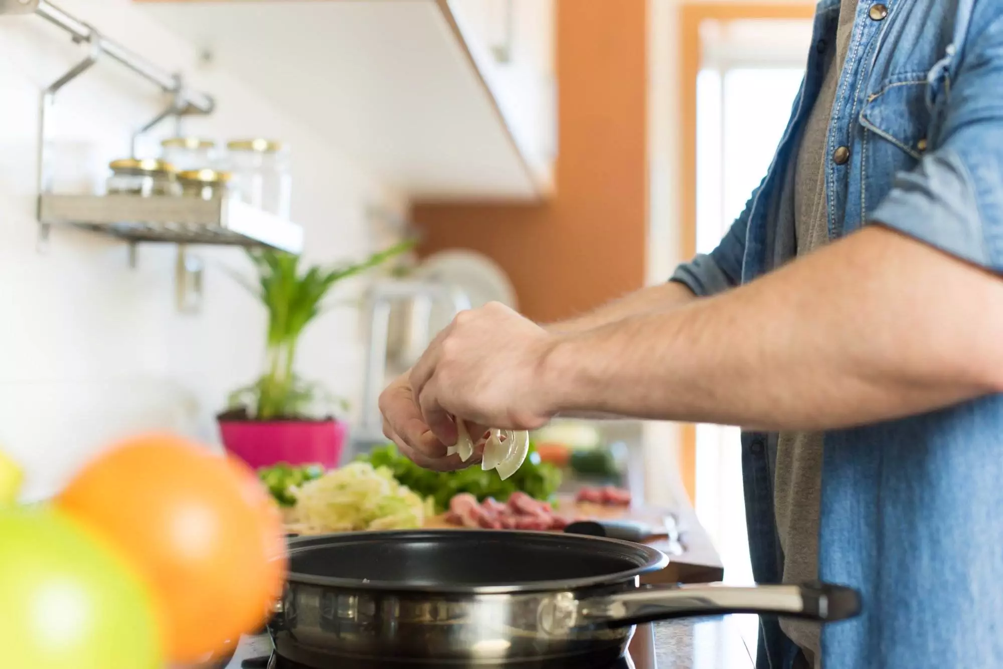 Man cooking, squeezing lemon in kitchen.