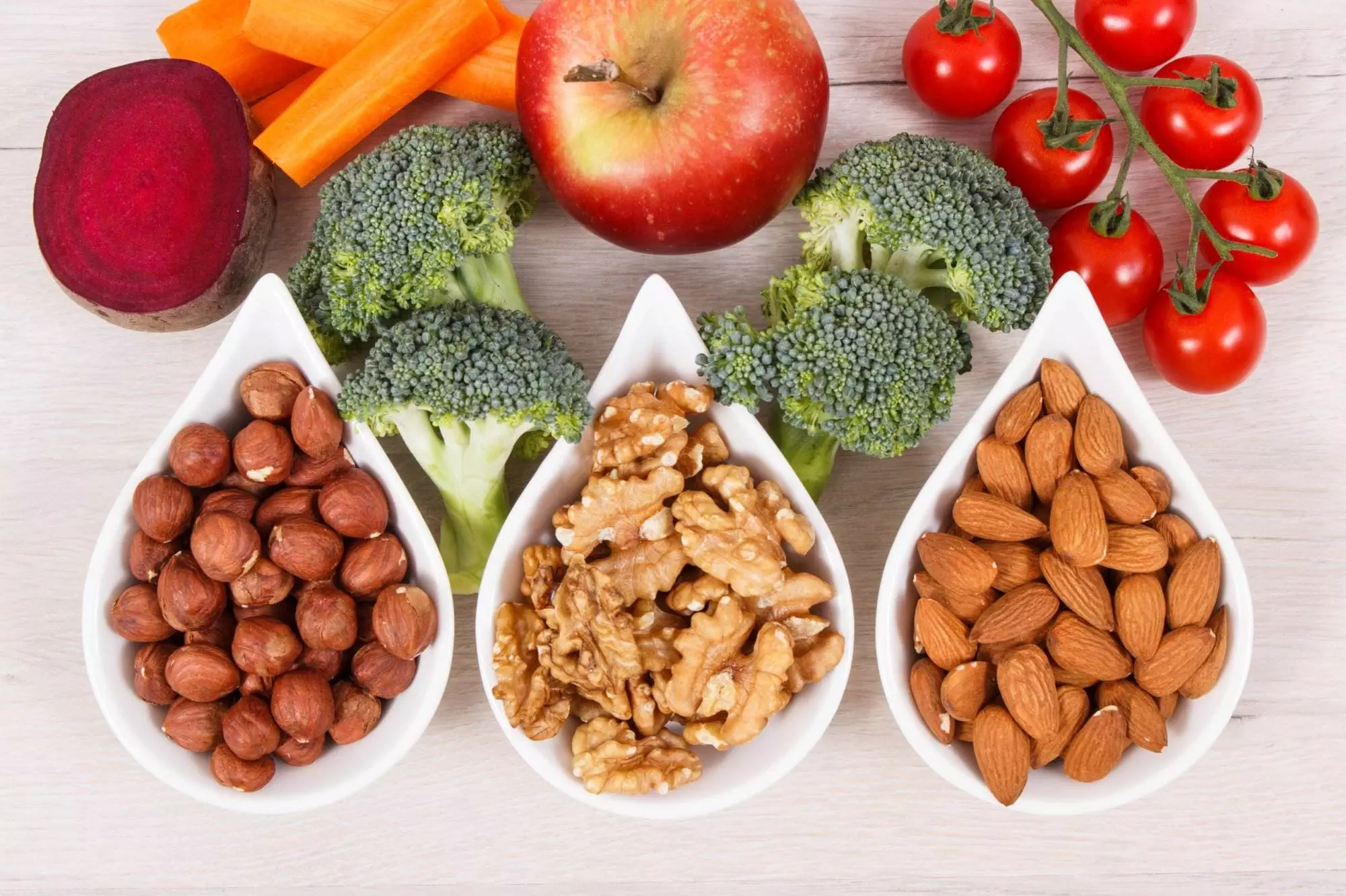 Variety of healthy nuts and vegetables on table.