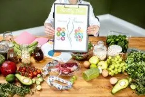 Nutritionist presenting healthy diet chart with fresh food.