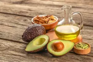 Healthy Fat avocado oil nuts on a wooden background. Keto food.