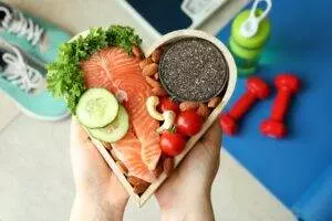 Healthy food and exercise concept with salmon and dumbbells.