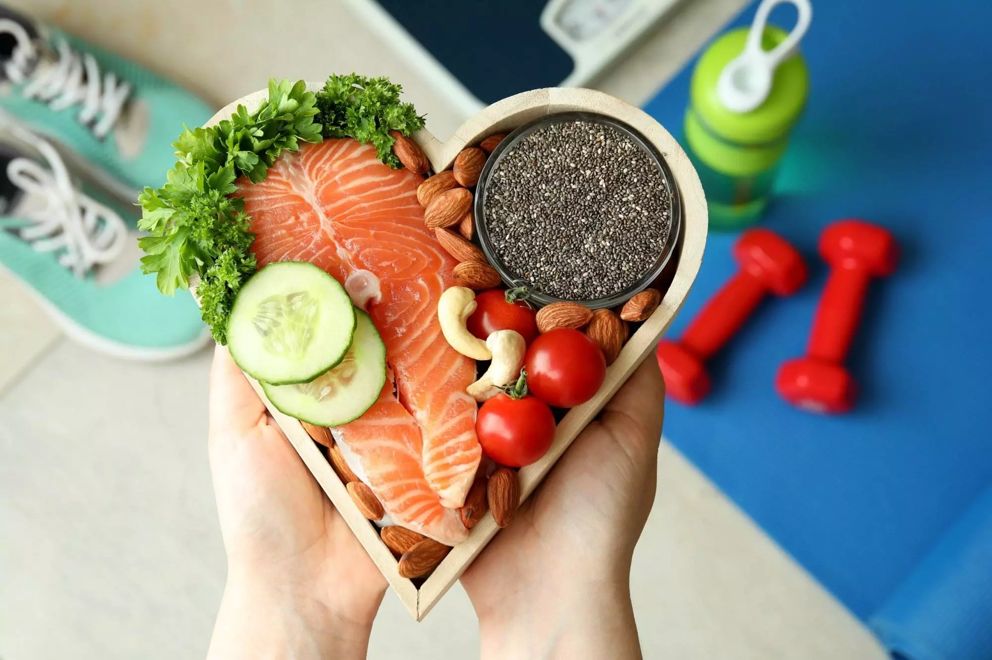 Healthy food and exercise concept with salmon and dumbbells.