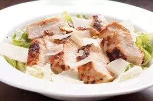 Grilled chicken Caesar salad on a plate.