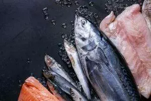 Fresh assorted seafood on dark wet surface. Keto diet