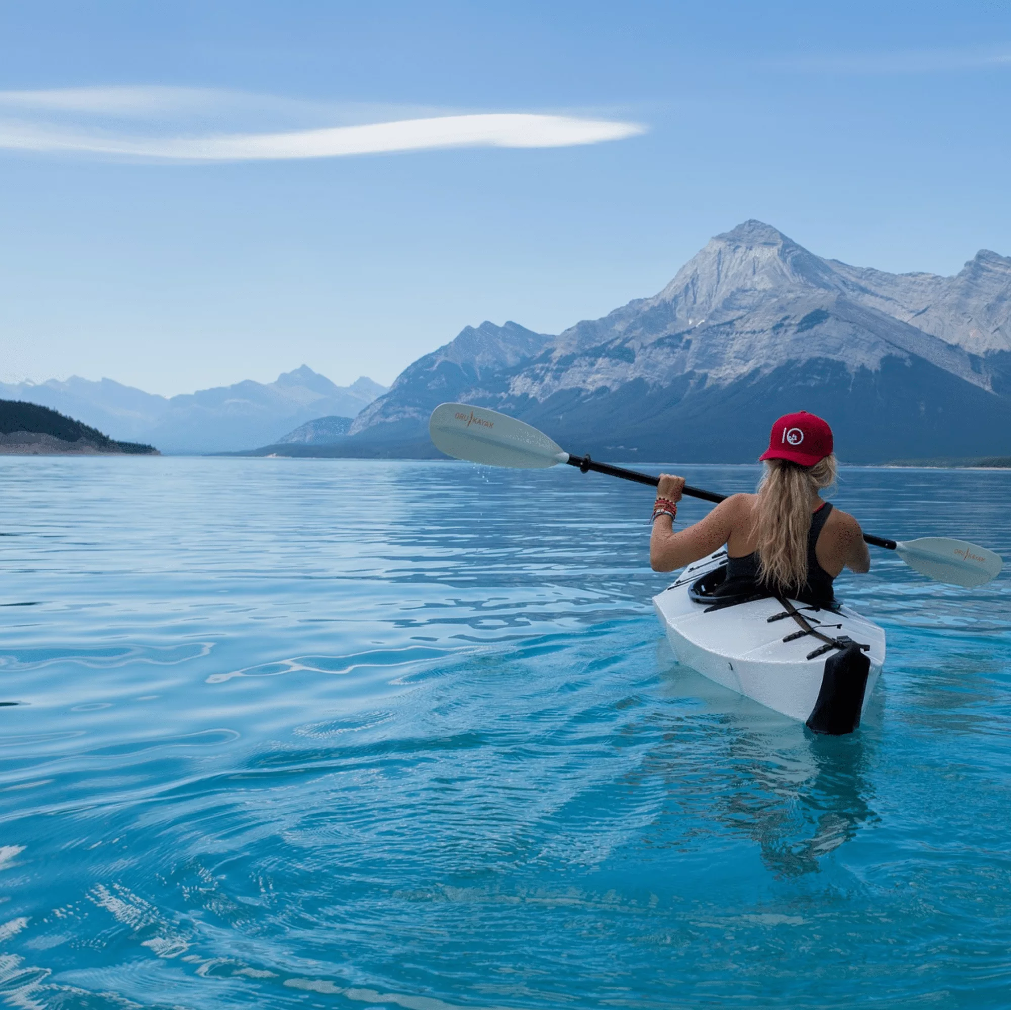 Woman kayaking in serene mountain lake