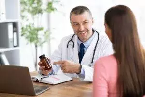 Doctor explaining medication to patient in office.