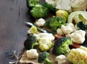 Fresh broccoli and cauliflower on wooden table.