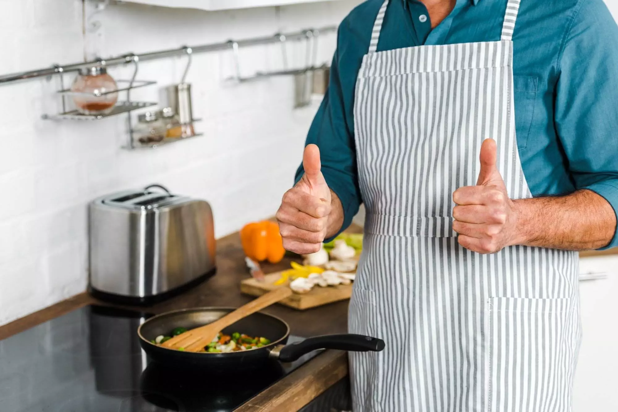 Man frying vegetables showing thumbs up