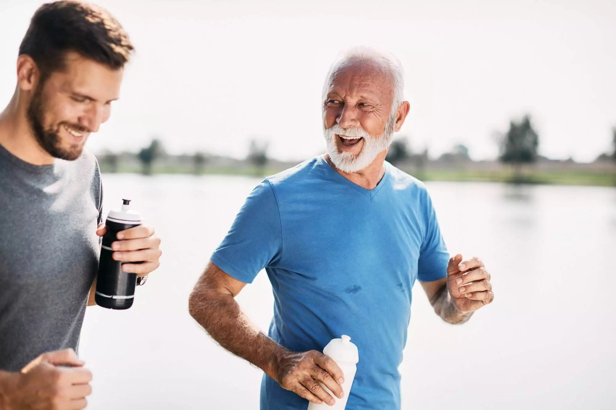 Two men jogging and smiling outdoors.
