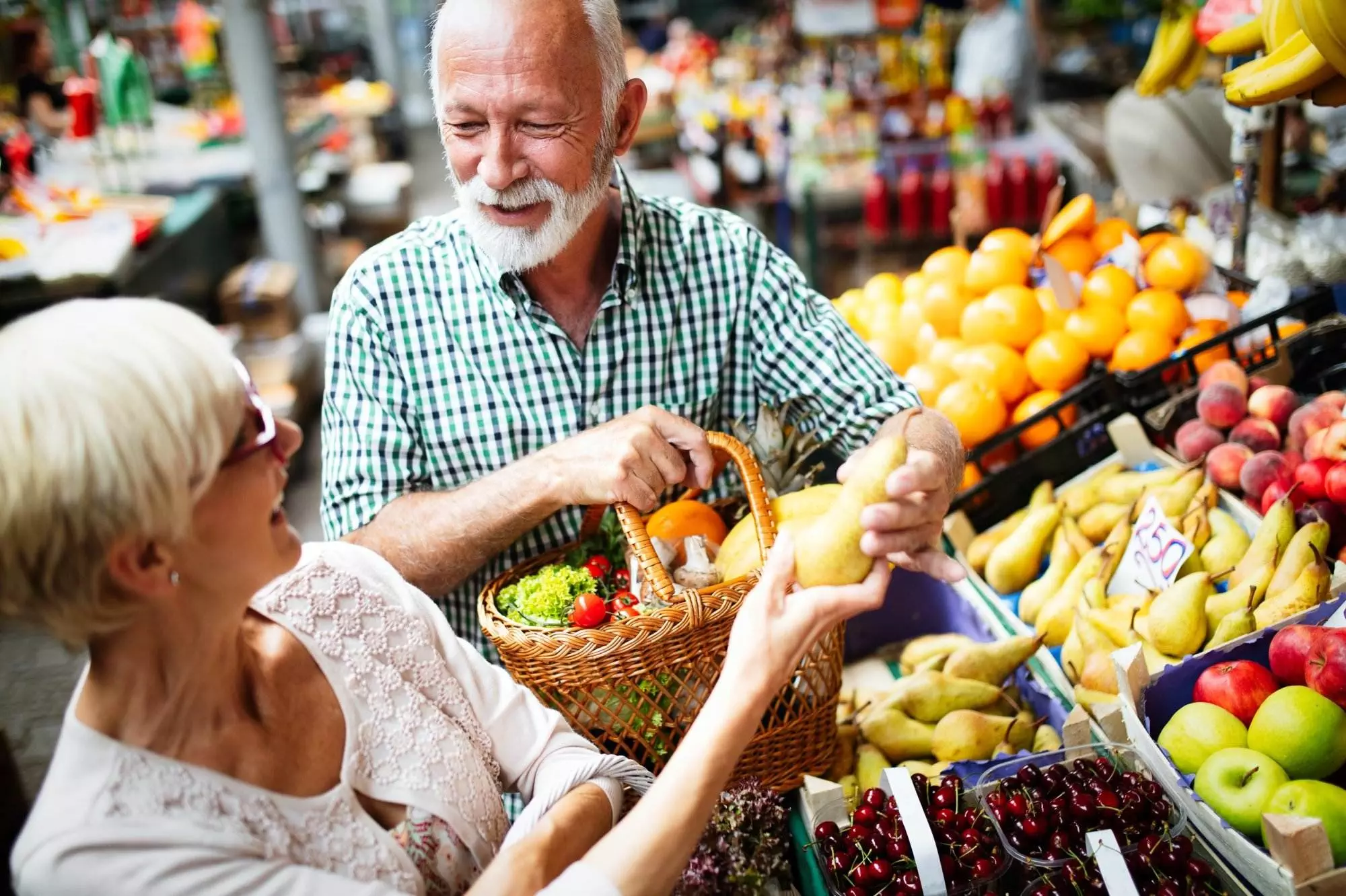 Senior couple shopping for fresh produce at market.