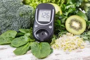 Glucometer on healthy vegetables and fruits.