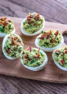 Deviled eggs with bacon on wooden board. Keto 