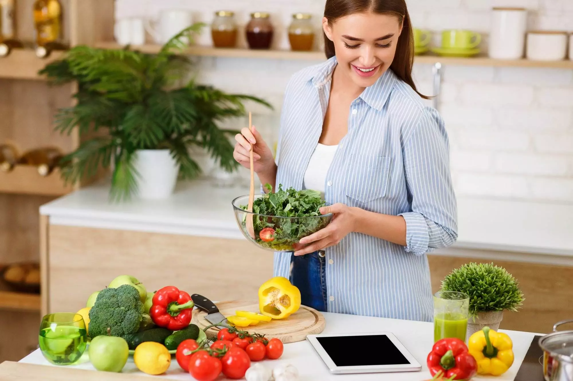 Woman Cooking Salad, Looking For Recipe On Tablet Online. Keto healthy concept.