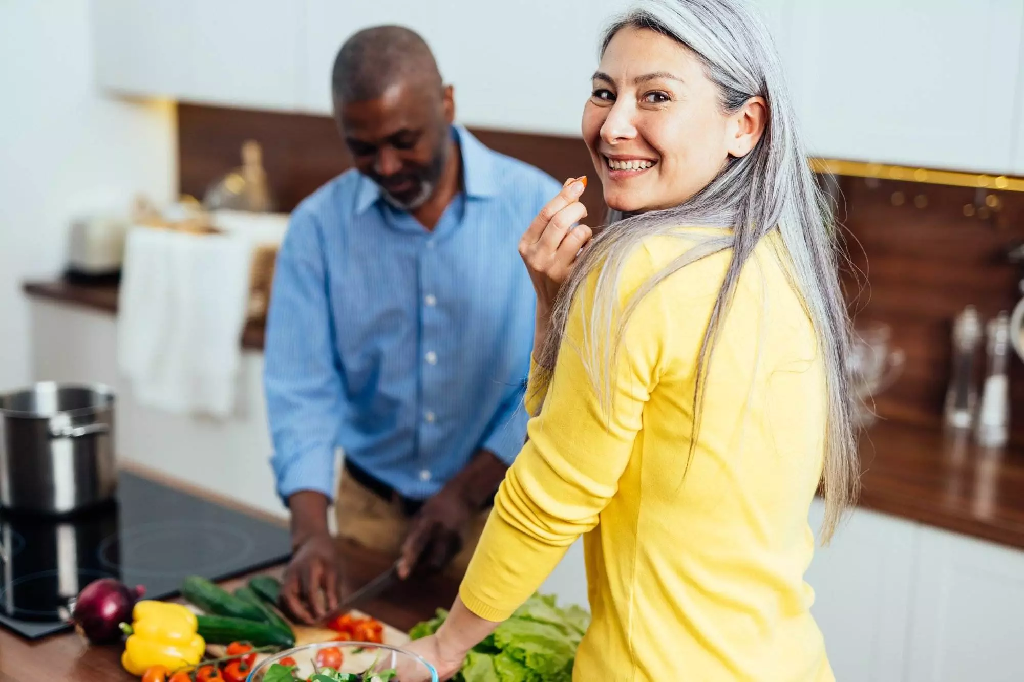 Couple preparing salad in kitchen together. Ketogenic healthy lifestyle