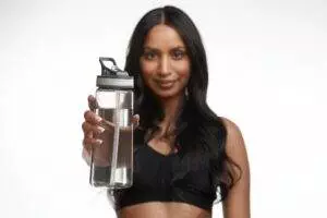 Woman presenting clear reusable water bottle.