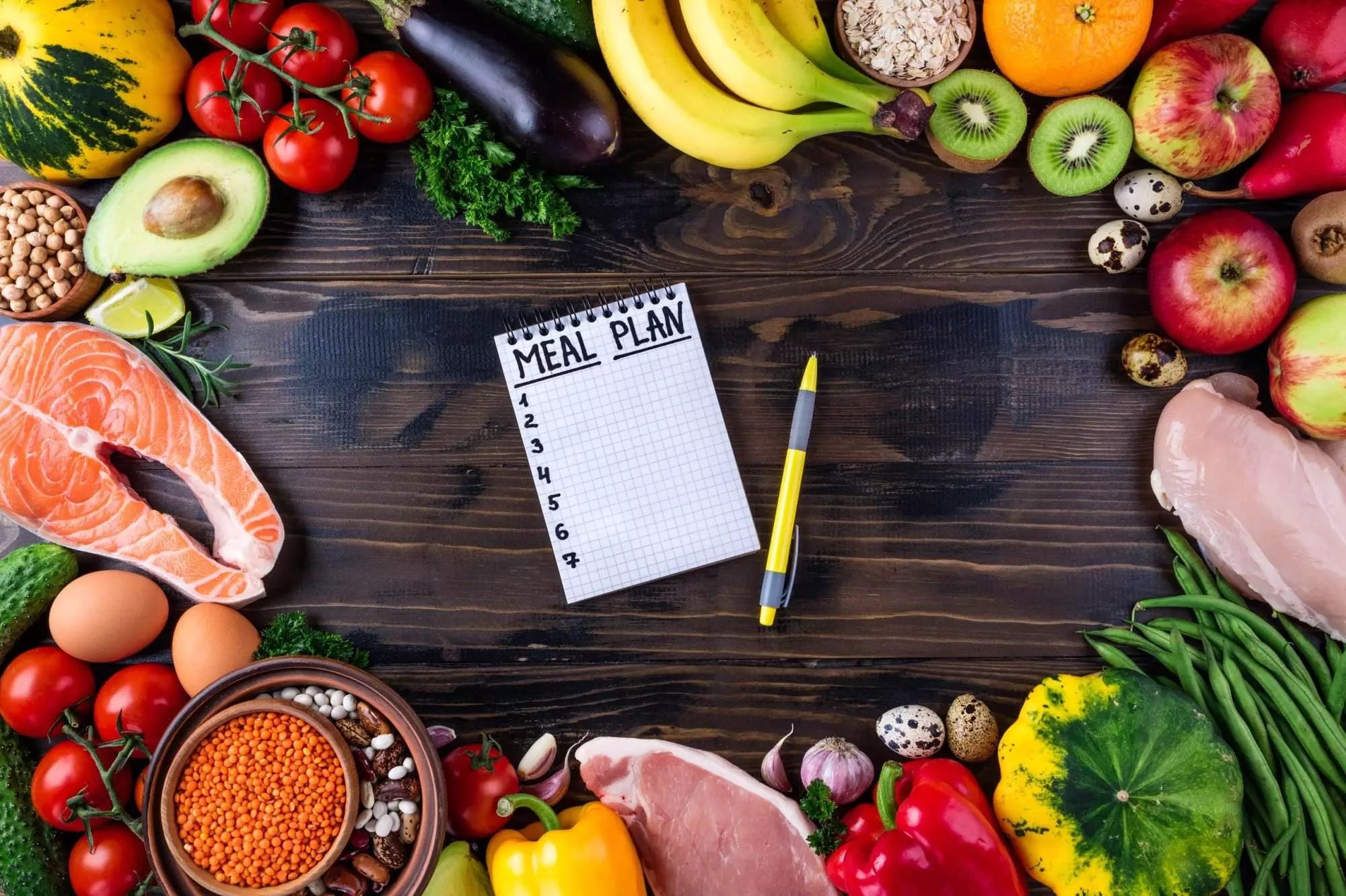 Healthy meal planning with fresh ingredients and notepad.