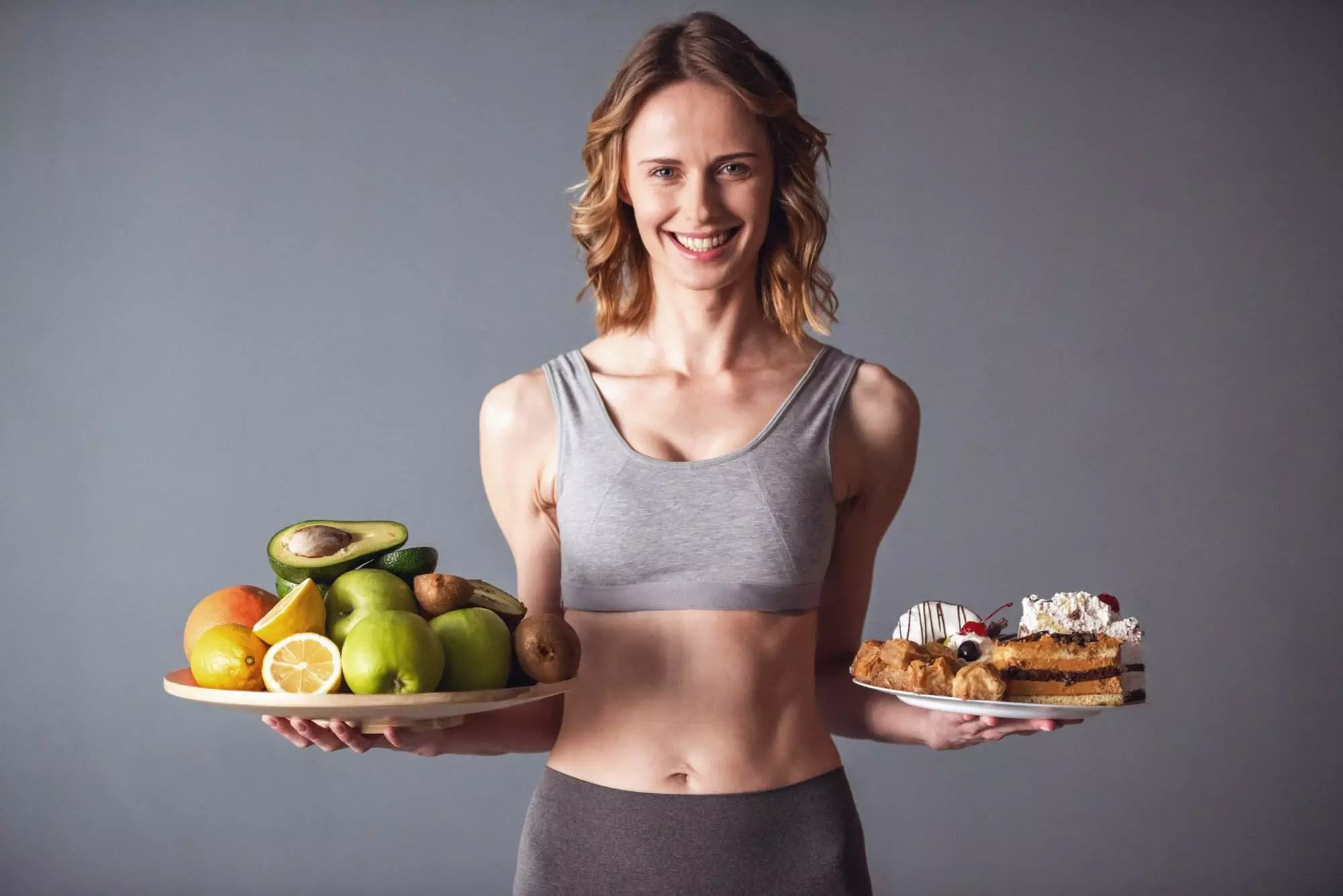 Woman balancing healthy fruits and unhealthy desserts.