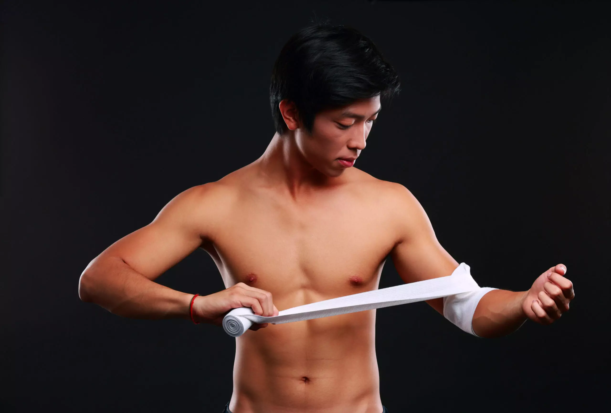Man wrapping wrist with athletic bandage, fitness concept.